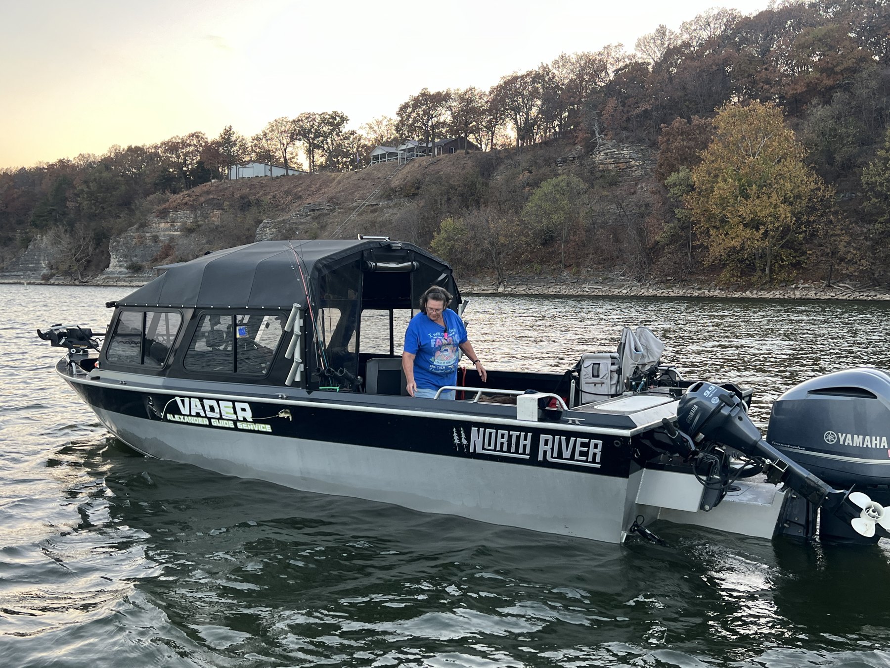 Alexander Guide Service North River boat with a covered cabin on Grand Lake